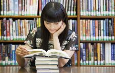 Asian woman reading book in library